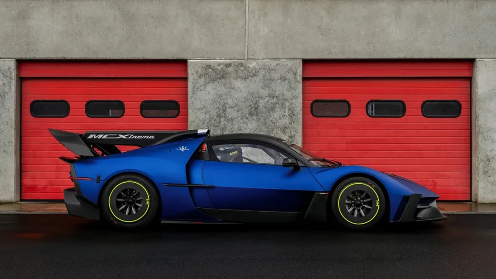 Blue Maserati MCXtrema in front of garage doors.